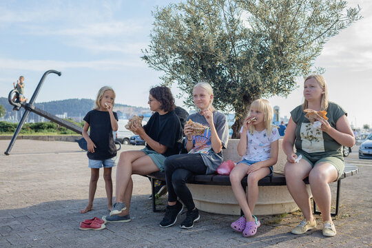 Women and kids eating gyros outside