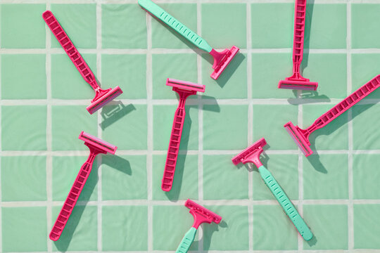 Colorful Disposable Razors on Mint Green Tiled Background