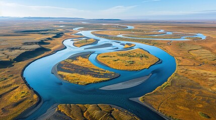 Aerial View of Serpentine River Flowing Through Vibrant Autumn Landscape with Clear Blue Sky