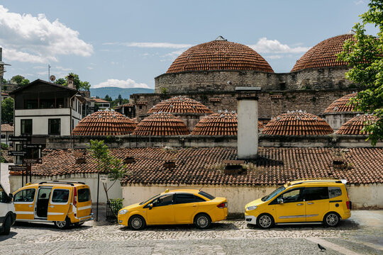 Yellow Cars in Front of Historic Hamam
