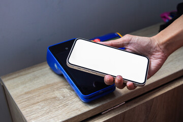 Hand Tap Phone on Modern Touchscreen Card Payment Machine Doing Cashless Payment