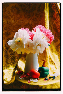 White and Pink Peonies in a White Pitcher on a Yellow Tablecloth.
