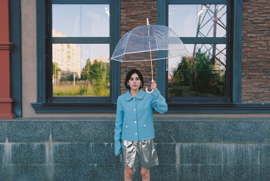 Woman posing outdoors with umbrella