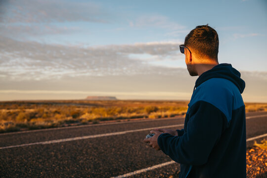 Man flying a drone in the Australian desert near Mount Conner