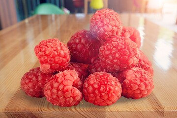 Tasty fresh ripe raspberries on desk