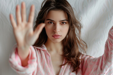Fototapeta premium Young woman, hand raised as a stop sign, domestic violence