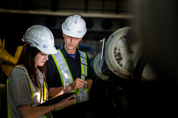 Factory engineers inspect on machine. Confident team mature businessman with laptop standing by...