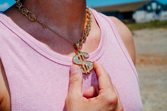 man wearing a necklace with a dollar symbol pendant