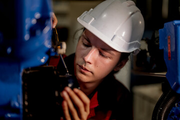 male engineer workers maintenance automatic robotic arm machine in a factory. worker checking and repairing automatic robot hand machine. technician worker check for repair factory machine.