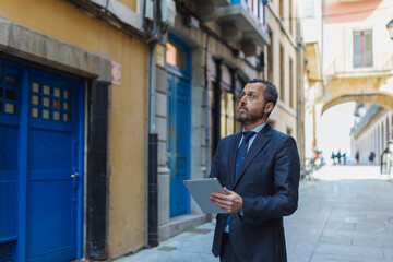 Real estate agent with tablet in alleyway