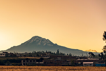 Chimborazo, fotografia durante la tarde, se puede ver un campo de trigo, el cielo naranja por el...