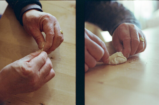 A close-up of a man's hand making dumplings