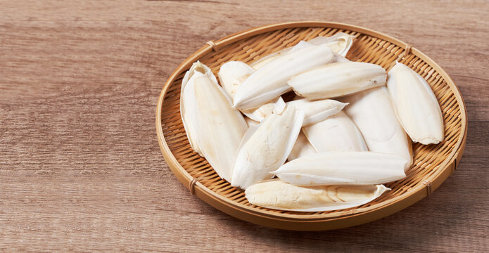 pile of dry cuttlebone or cuttlefish bone shell animal feed food for bird and pet on wood background in wooden plate with copy space