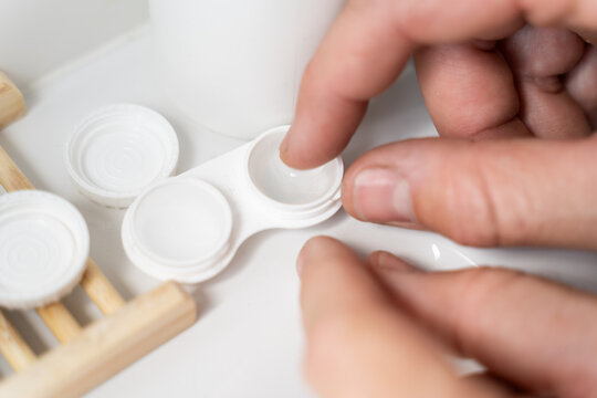 Man putting on contact lenses