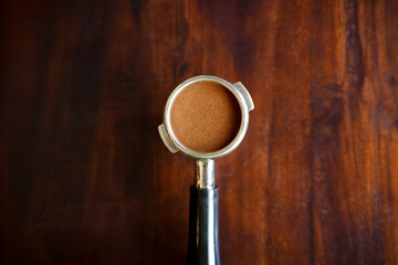 Top view of ground coffee in porta filter or portable coffee filter handle and ground coffee for a coffee making machine