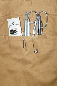 Formal trousers and silver metal tools in the pocket with flashlight
