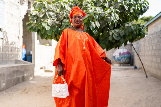 Senegalese woman wearing traditional clothes posing in a backyard