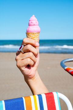 man on the beach has a snowman-shaped ice cream cone