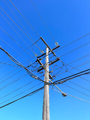 Telephone wires on a utility pole amongst blue sky
