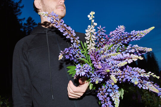 a bouquet of lupins in a man's hand