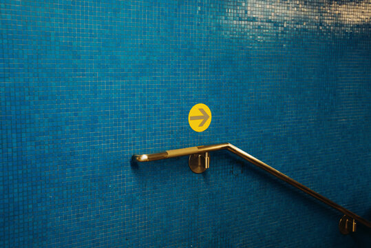 Yellow Arrow on Blue Tiled Wall