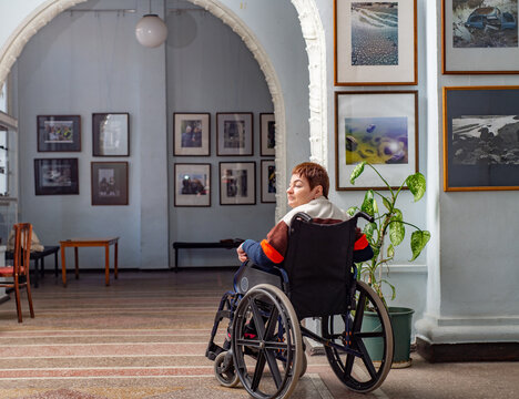Person in a wheelchair looks at art work in the hall