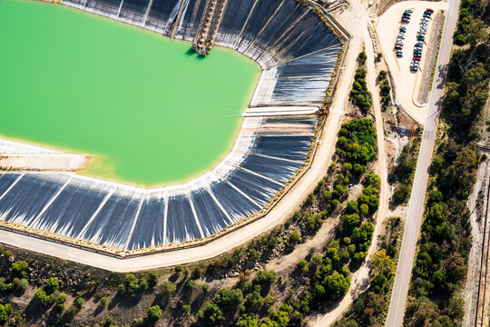 Aerial views over large industrial dam and tailing ponds