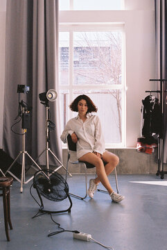 Woman posing on chair in photo studio