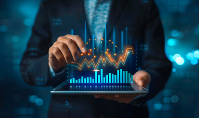 Businessman holding a tablet with a financial graph and trading chart icon on a virtual screen, business plan , stock market technology concept 