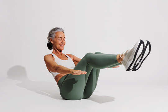 Senior woman doing crunches, maintaining fitness and healthy lifestyle