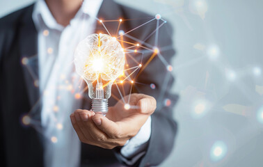 A businessman holding a light bulb with a glowing network connection and brain icon on a white background, concept for thinking , new creative innovation business