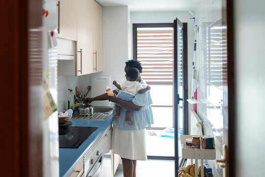 mother doing homework in the kitchen while carin baby