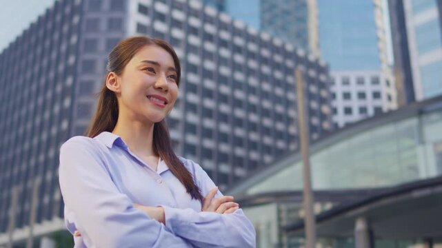 Asian youg beautiful businesswoman standing outdoor in city skyscrapers.