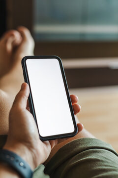 Man holding smartphone on sofa