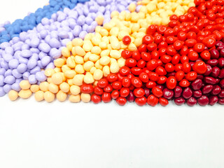 Various colors of masterbatch granules on a white background. Polymer carriers of color pigments in...