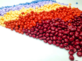 Various colors of masterbatch granules on a white background. Polymer carriers of color pigments in the plastics industry