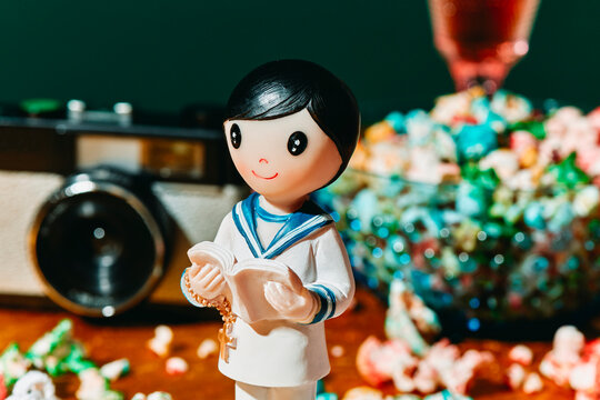 camera, popcorn and figurine of a boy in his first communion
