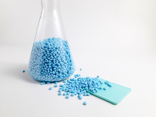 Electric blue masterbatch granules in erlenmeyer flask isolated on white background.Color pigment...