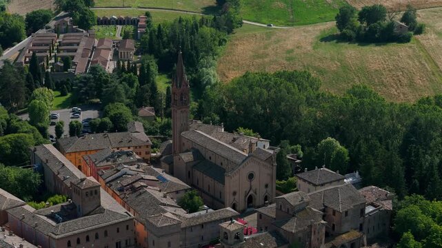 Aerial view of the historic Church of Saints Senesio and Teopompo nestled within the charming landscape of Modena, Italy, surrounded by lush greenery.