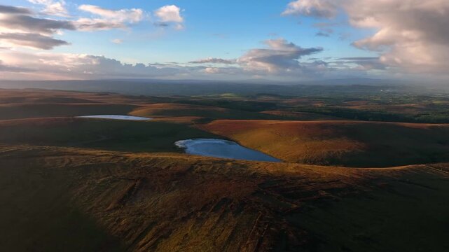 Bragan, County Monaghan, Ireland, September 2022. Drone ascends while pushing towards Lough na Heery on the Irish border with Northern Ireland at golden hour with Lough Navarad in the background.