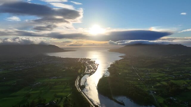 Flagstaff, County Down, Northern Ireland, November 2022. Drone pulls backwards north west over the Newry river during the dawn sunrise with Warrenpoint and Carlingford Lough in the distance.