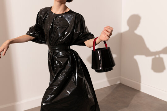 Modern Fashion Model In Black Shiny Dress And Handbag