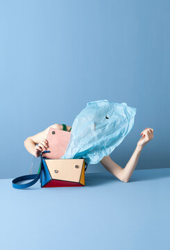 Colorful Handbag with Blue Tissue Paper Against Blue Background
