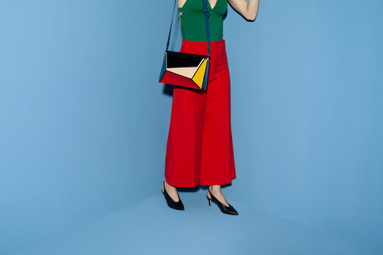Stylish Woman Wearing Colorful Outfit Against Blue Background