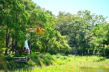 A colorful dragon sculpture at Hutoupi Scenic Area in Tainan's Xinhua District, set against a backdrop of lush greenery and a clear blue sky on a sunny day.