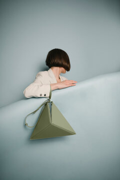 Elegant Woman with Unique Green Pyramid Handbag