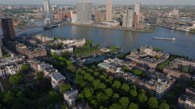 Aerial view of Rotterdam, featuring the vibrant cityscape, green spaces, and the famous erasmus bridge over the Nieuwe Maas river