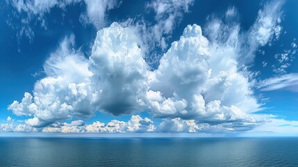 Stunning panoramic view of fluffy white clouds over a calm sea reflecting the clear blue sky. Perfect image for nature and weather concepts.