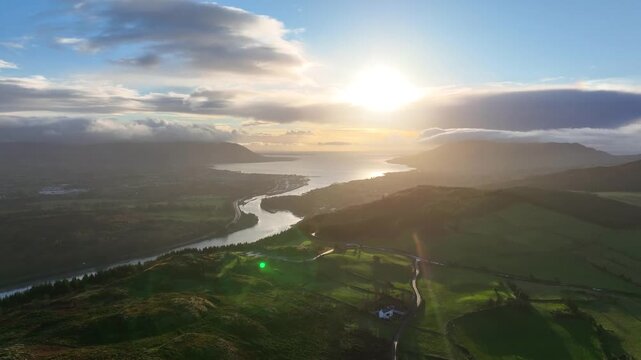 Flagstaff, County Down, Northern Ireland, November 2022. Drone pushes south east towards Warrenpoint as dawn breaks with clouds rolling over Slieve Foye and Carlingford Lough.