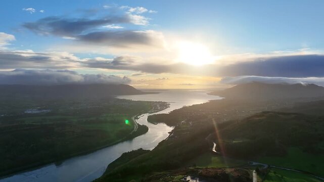 Flagstaff, County Down, Northern Ireland, November 2022. Drone pulls backwards facing south east above the Newry river with Carlingford Lough and Warrenpoint in the distance at golden hour.